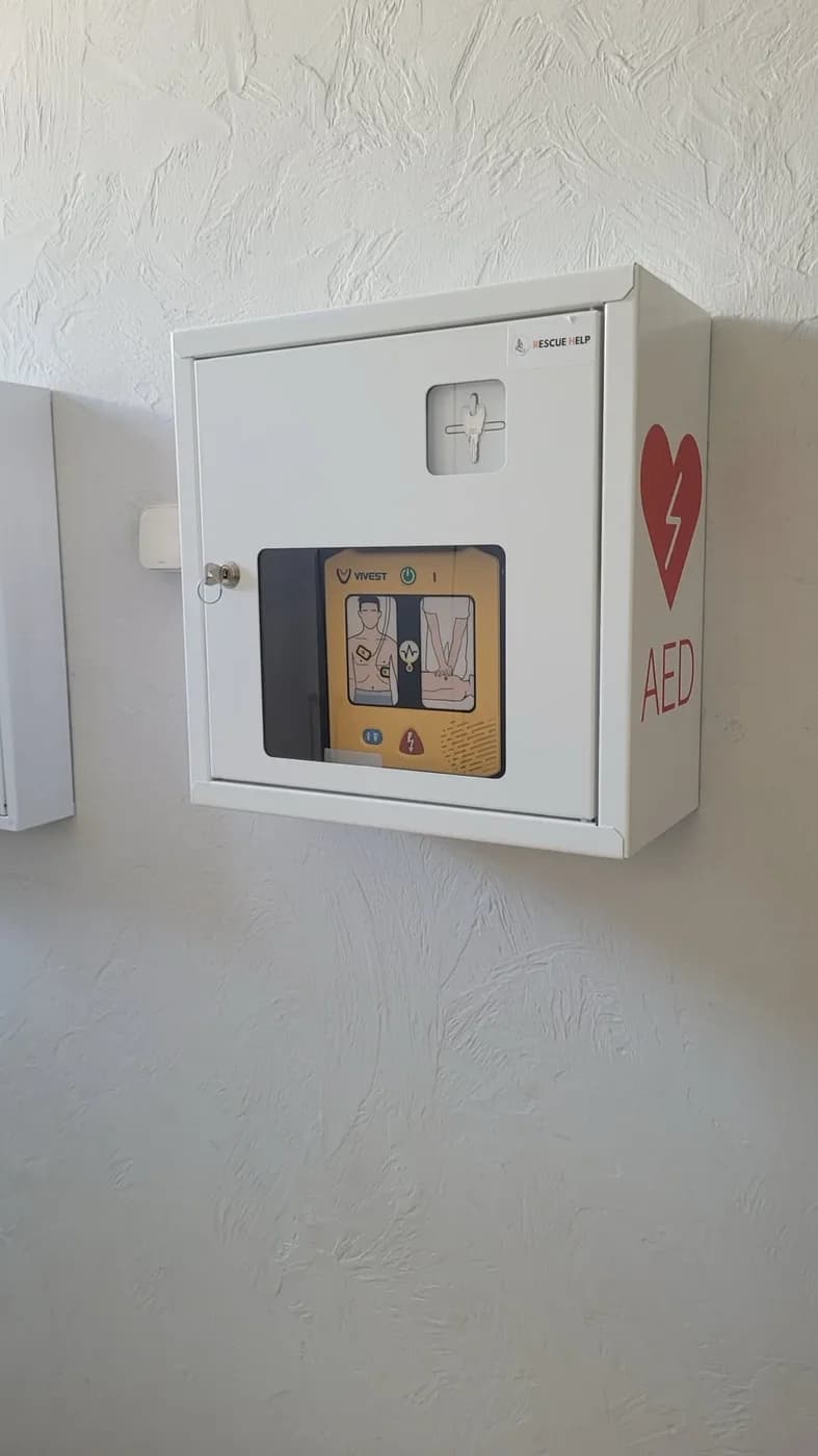 Biała szafka AED z ViVest na ścianie obiektu Buchcik